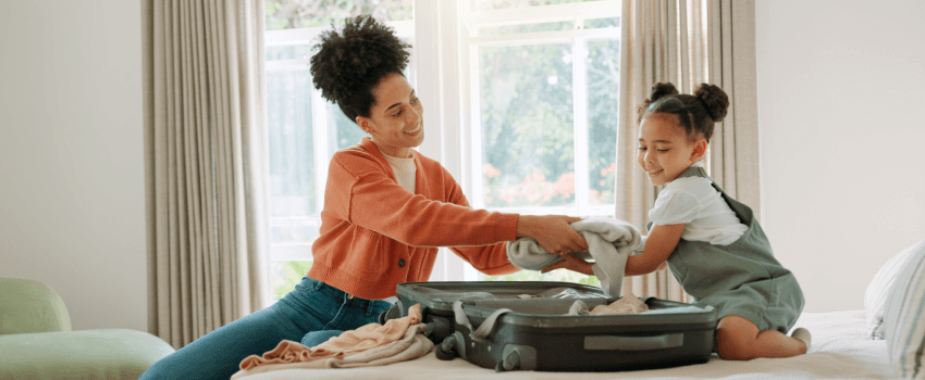 Mother preparing travel luggage with her daughter