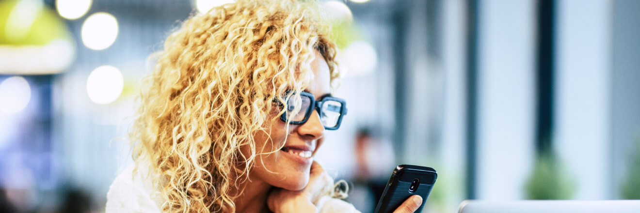 Woman smiling and looking at her mobile phone