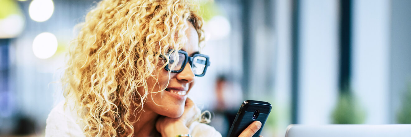 Women smiling while looking at her mobile phone