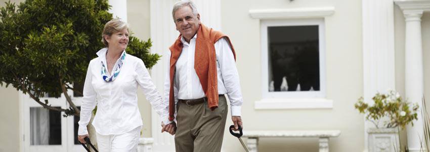 An elderly couple ready to travel with their suitcase